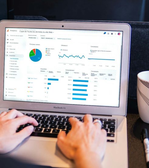 person using macbook pro on black table