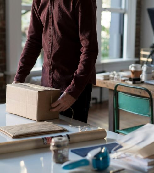 person holding cardboard box on table