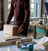 person holding cardboard box on table